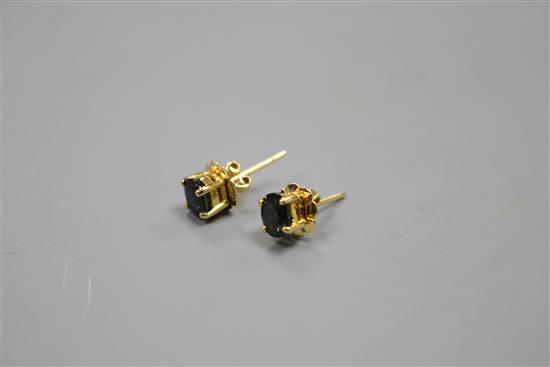 A pair of yellow metal (stamped 18k) and solitaire oval cut sapphire set eat studs, sapphires approximately 4.5mm in length,